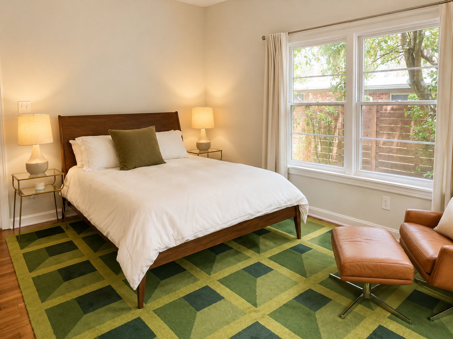 Primary bedroom with walnut bed and geometric green rug